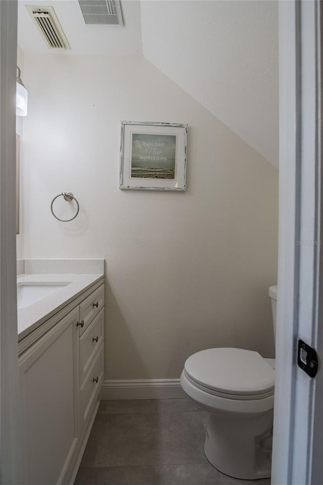 bathroom with vaulted ceiling, toilet, vanity, and visible vents