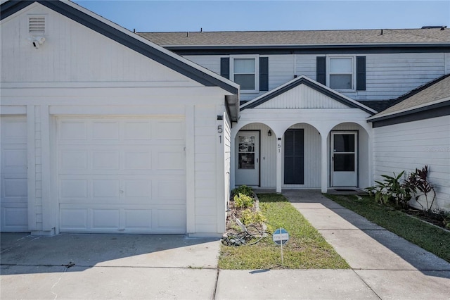 view of front of property with a garage, driveway, and a shingled roof