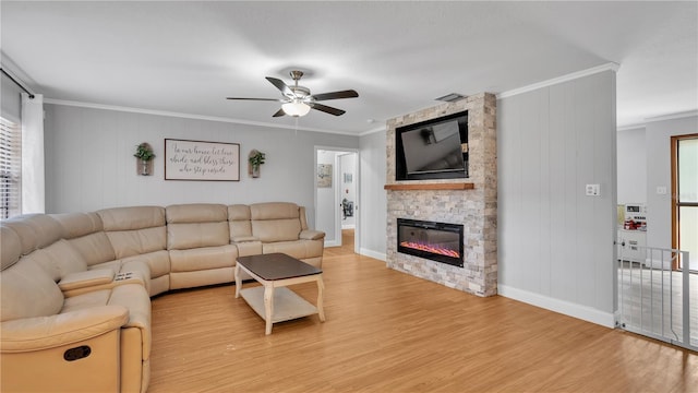 living room with light wood finished floors, visible vents, ceiling fan, ornamental molding, and a fireplace