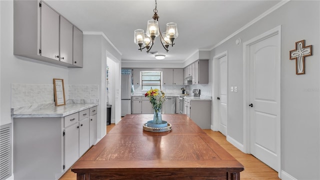 kitchen featuring a chandelier, stainless steel appliances, gray cabinets, and crown molding