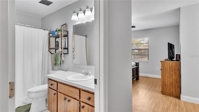 full bathroom with baseboards, toilet, a shower with curtain, wood finished floors, and vanity