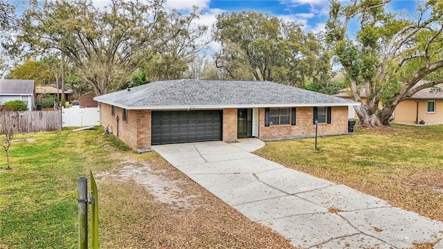 ranch-style home featuring brick siding, fence, a garage, driveway, and a front lawn