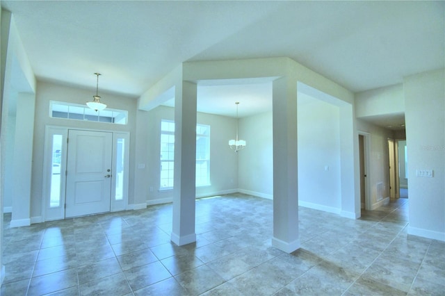 foyer featuring baseboards, light tile patterned flooring, and a notable chandelier