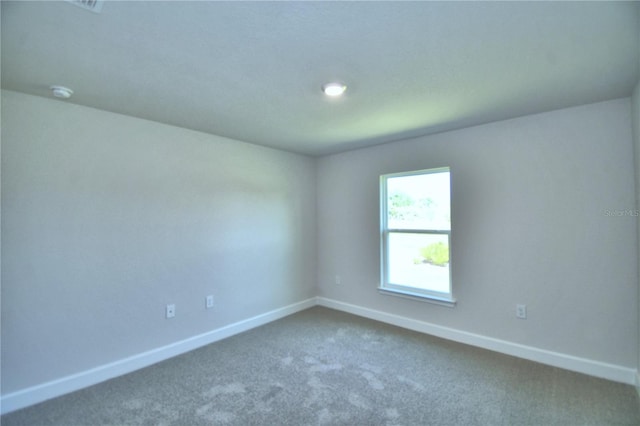 unfurnished room featuring carpet and baseboards