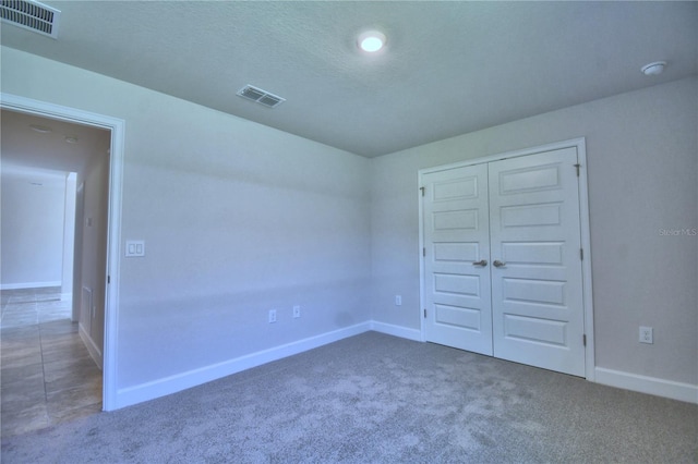 unfurnished bedroom featuring carpet floors, baseboards, and visible vents