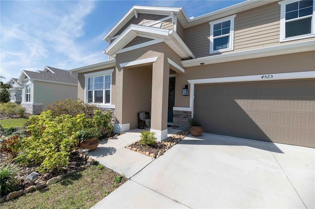 view of front of property with driveway, stone siding, and stucco siding