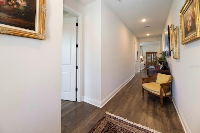 corridor featuring recessed lighting, visible vents, baseboards, and wood finished floors