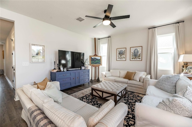 living area with dark wood finished floors, visible vents, and a ceiling fan