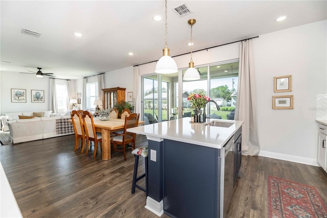 kitchen with visible vents, light countertops, a sink, and open floor plan