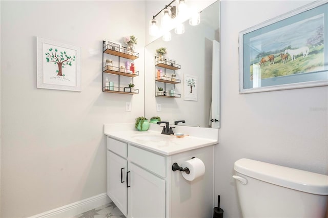 half bath featuring vanity, toilet, and baseboards