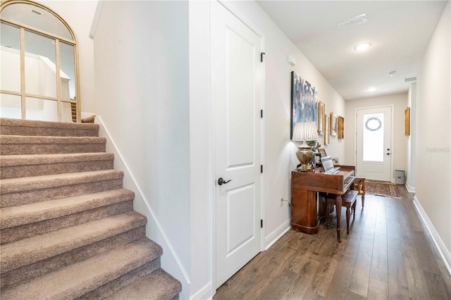 interior space featuring visible vents, stairway, baseboards, and wood finished floors