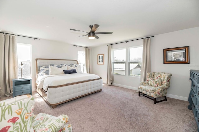 bedroom with a ceiling fan, light carpet, and baseboards