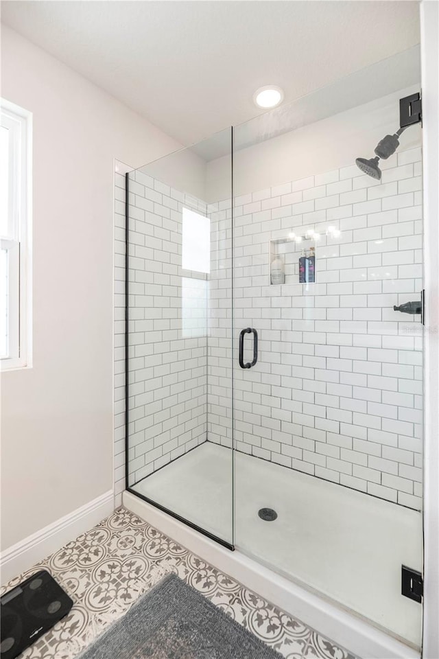 bathroom featuring a shower stall, baseboards, and tile patterned floors