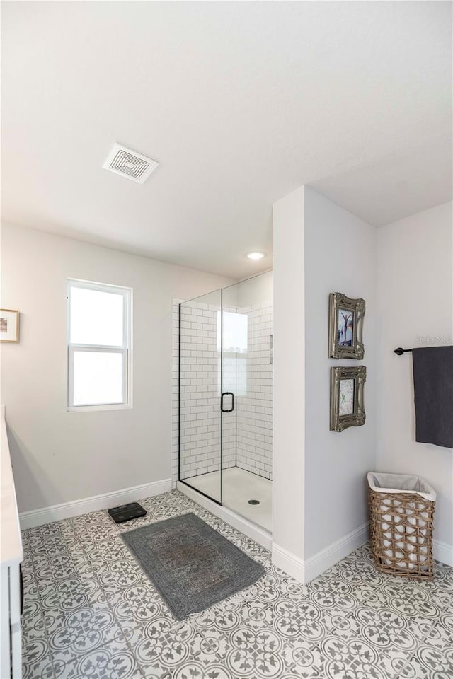 bathroom featuring baseboards, a stall shower, visible vents, and tile patterned floors