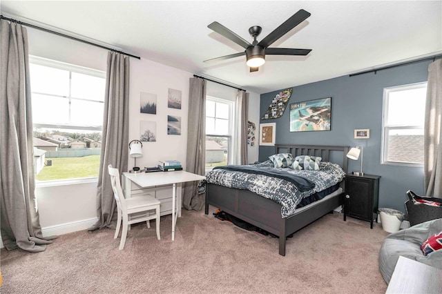 bedroom with a ceiling fan, light colored carpet, and baseboards