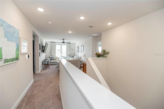 hallway featuring baseboards, recessed lighting, an upstairs landing, and light colored carpet