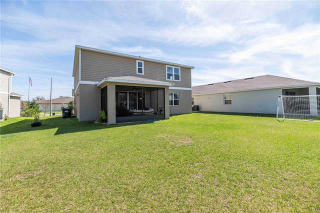 rear view of house with stucco siding, central AC unit, and a yard