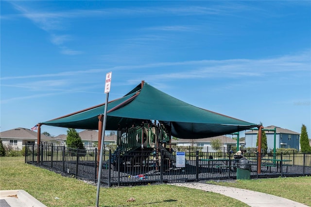 view of property's community with playground community, a lawn, and fence