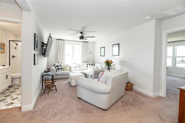 living area featuring light carpet, ceiling fan, plenty of natural light, and visible vents