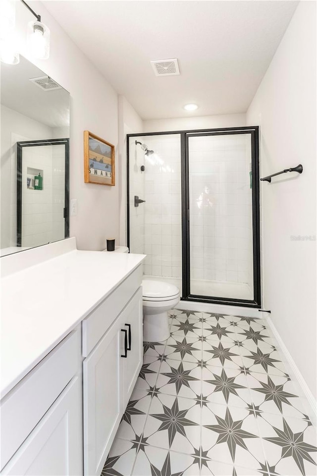 full bathroom featuring toilet, a shower stall, visible vents, and vanity