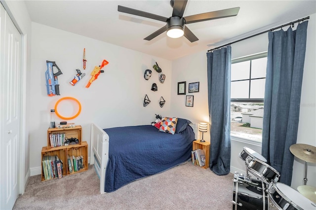 carpeted bedroom featuring ceiling fan, baseboards, and a closet