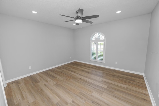 spare room featuring baseboards, a textured ceiling, recessed lighting, and light wood-style floors