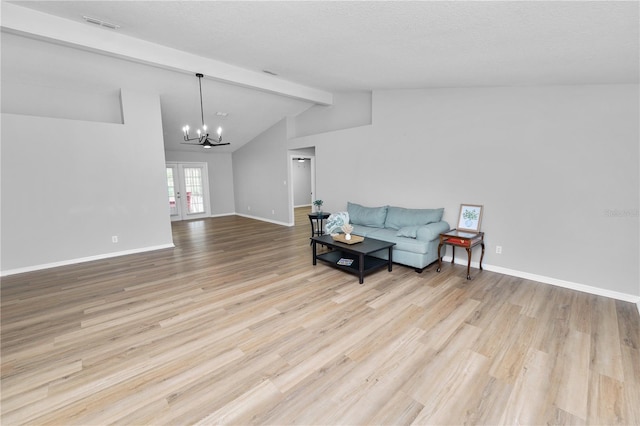 living area with lofted ceiling with beams, a notable chandelier, wood finished floors, baseboards, and french doors