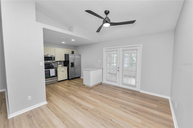 kitchen with french doors, light countertops, appliances with stainless steel finishes, vaulted ceiling, and light wood-type flooring