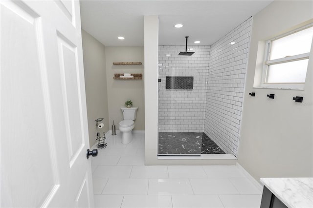 full bath with baseboards, tiled shower, vanity, and toilet