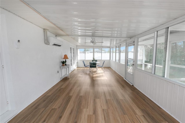 unfurnished sunroom with ceiling fan and a wall mounted AC