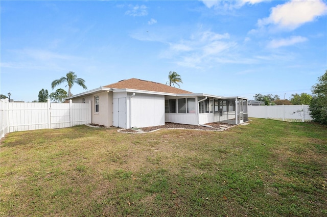 back of property featuring a sunroom, a fenced backyard, and a yard