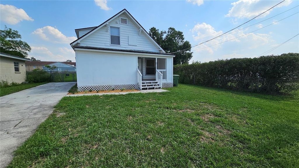 rear view of property with a lawn and fence