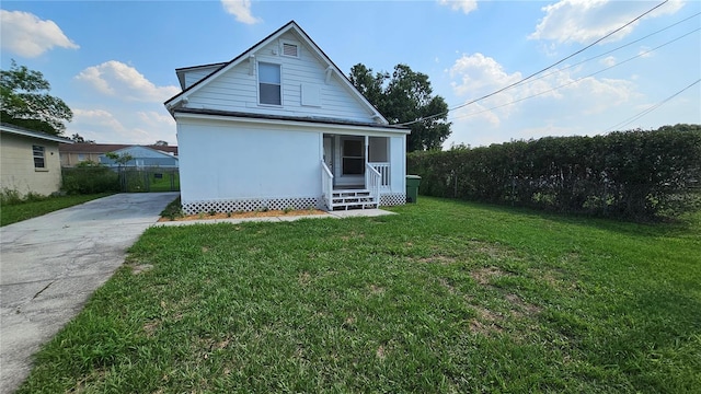 rear view of property with a lawn and fence