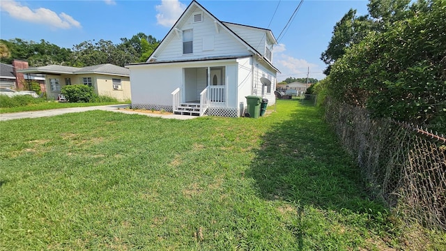 exterior space with a front yard, covered porch, and fence