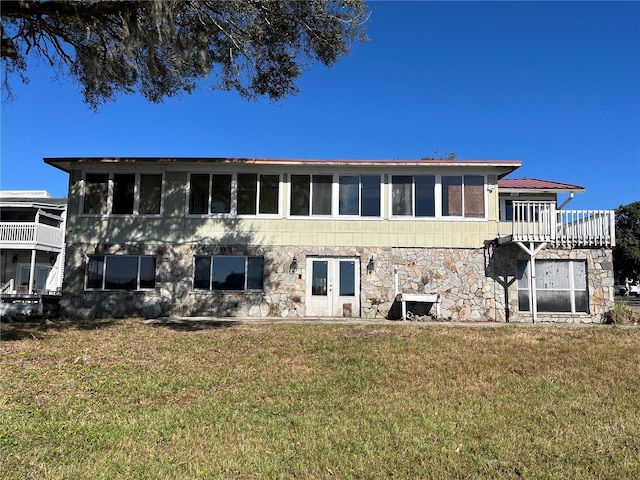 330 Callitris Ave, Polk City, FL 33868 - back of house featuring stone siding and a lawn