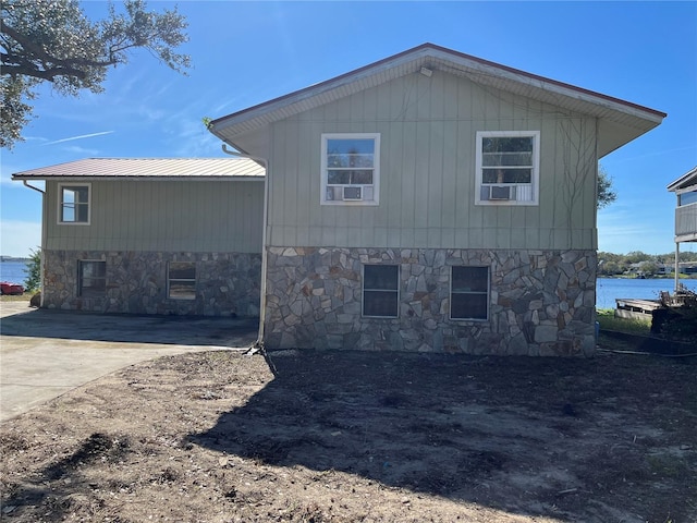 330 Callitris Ave, Polk City, FL 33868 - view of side of property with metal roof, stone siding, and driveway