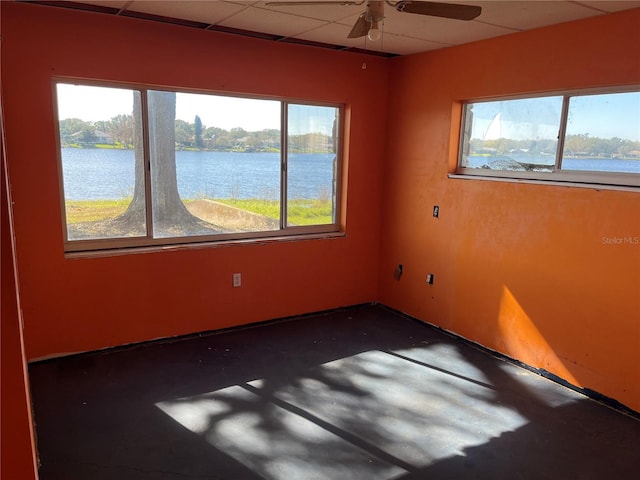 330 Callitris Ave, Polk City, FL 33868 - empty room featuring a drop ceiling, a water view, a ceiling fan, and a healthy amount of sunlight