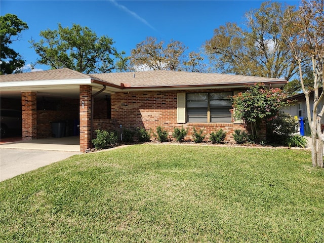 view of front of home featuring brick siding, roof with shingles, concrete driveway, a front yard, and an attached carport