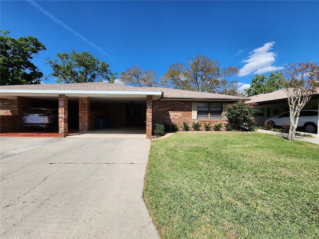 ranch-style house featuring brick siding, an attached carport, concrete driveway, and a front yard