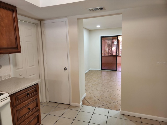 kitchen with light tile patterned floors, light countertops, visible vents, and baseboards