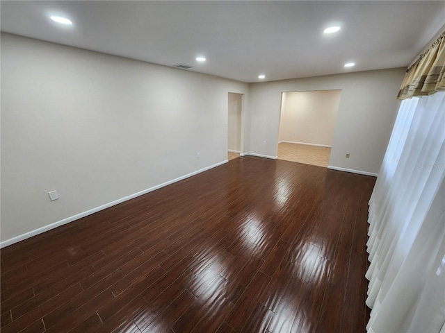 empty room with recessed lighting, visible vents, baseboards, and wood finished floors