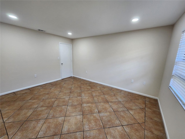 unfurnished room featuring baseboards, visible vents, and recessed lighting