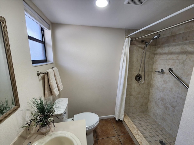 full bath featuring toilet, visible vents, vanity, tiled shower, and tile patterned floors