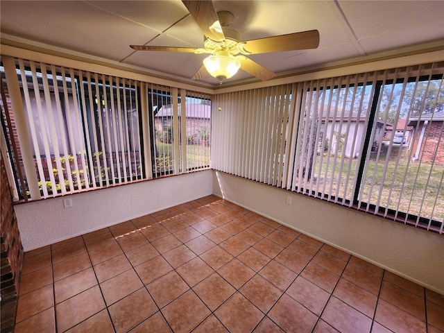 unfurnished sunroom featuring a ceiling fan