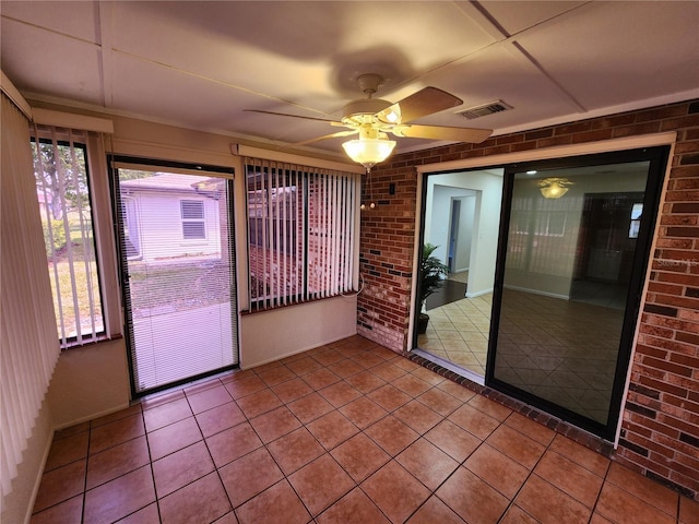 unfurnished sunroom with visible vents and a ceiling fan