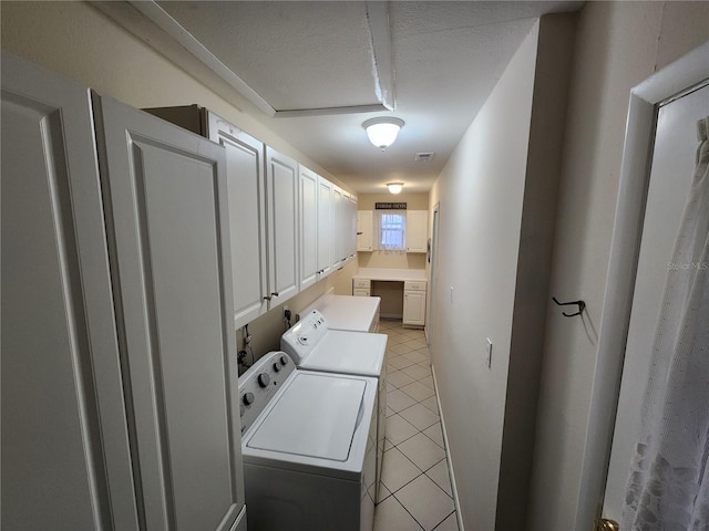 clothes washing area with cabinet space, light tile patterned floors, visible vents, and separate washer and dryer