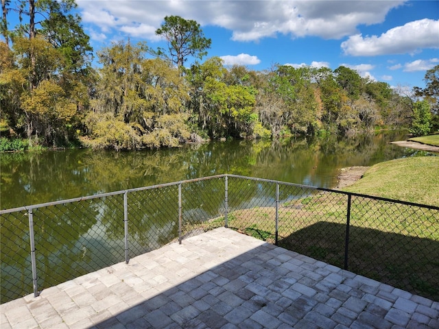 exterior space with a water view and fence