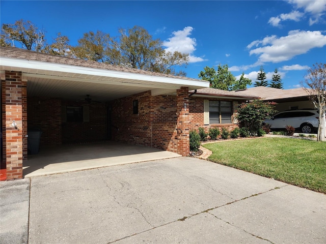 view of front of house featuring driveway, brick siding, an attached carport, and a front yard