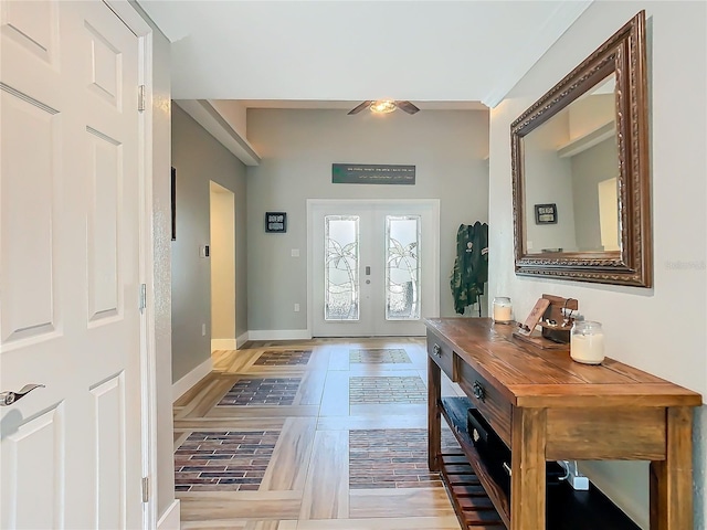 foyer featuring baseboards and french doors