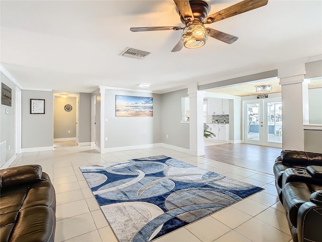 living room featuring light tile patterned floors, ceiling fan, visible vents, french doors, and decorative columns